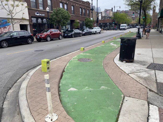 Bike lane that a truck typically parks on, now with cement blocks glued onto it to act as bollards