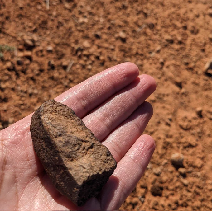 A Meteorite fragment in the palm of a hand