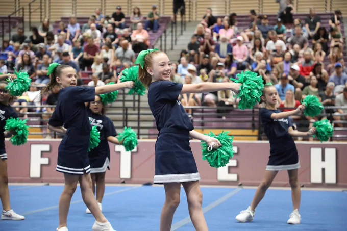 Image of cheerleaders smiling with their pom poms out