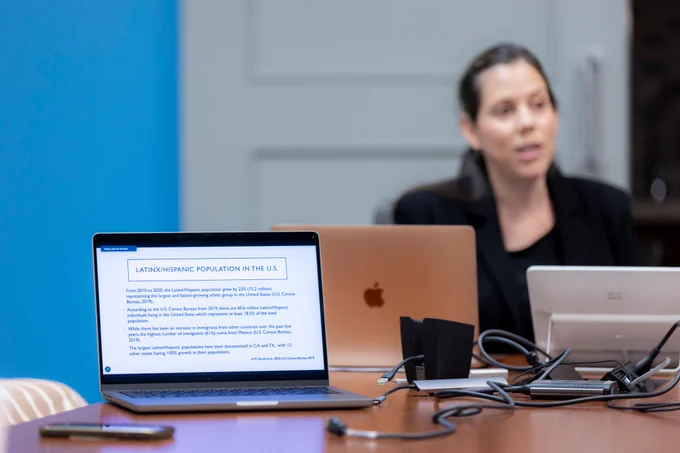 A laptop shows a slide from the talk.