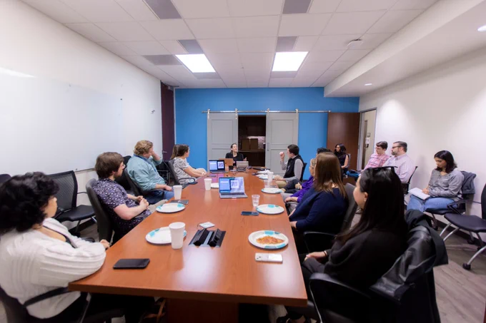A room full of attendees watch as the presenter answers a question.