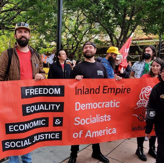 A group of people standing behind a banner that says:

Inland Empire Democratic Socialists of America
Freedom, equality, economic, & social justice.