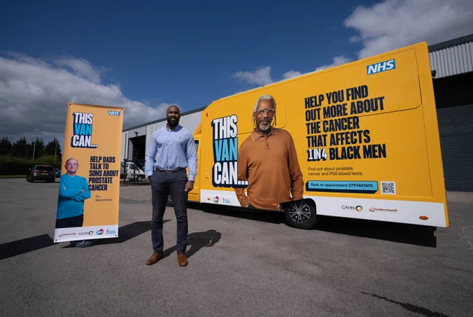 GM Cancer's Sotonye Tolofari stands in front of a yellow van with the words 'ThisVanCan Help you find out more about the cancer that affects 1 in 4 black men' written on the side and a photo of a black man wearing a dark orange jumper with grey hair and glasses. A pull up banner shows a white man in his 50s and says 'ThisVanCan Help dads talk to sons about prostate cancer.'