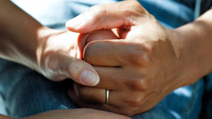 One hand holding another. 