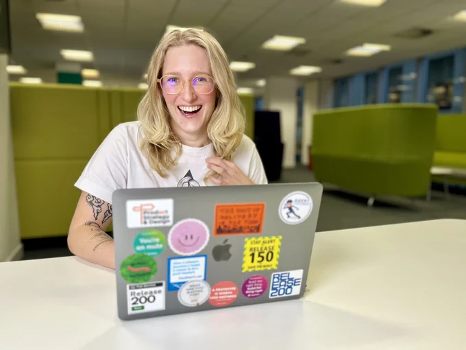 Kathryn sat at desk with a laptop open.
