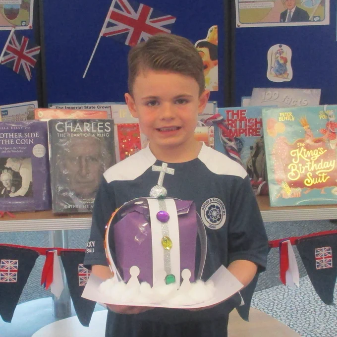 child holding crowns made from craft materials