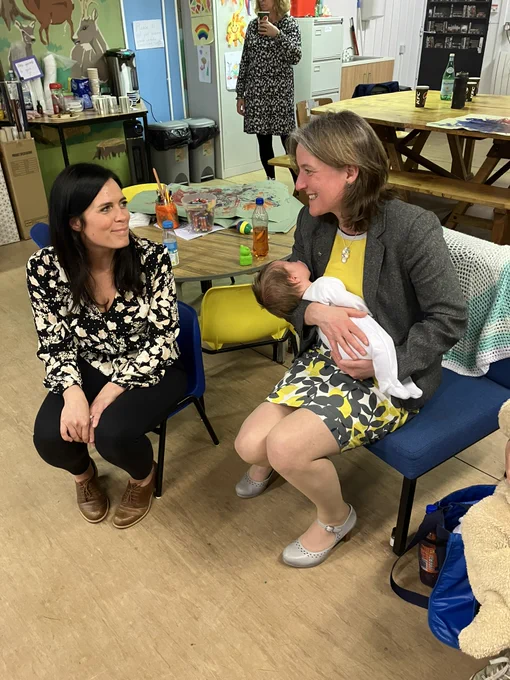 Minister holding a baby with a member of the group