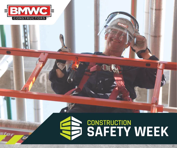 Construction Safety Week BMWC man standing on scaffolding with safety gear smiling 