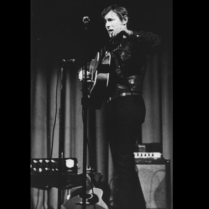 Gordon Lightfoot holding guitar, performing in Laurier's Theatre Auditorium