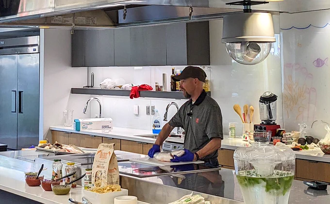 In the photo, Bolton prepares a meal featuring local bluefish.