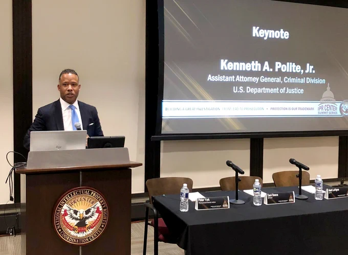 Assistant Attorney General Kenneth A. Polite, Jr. stands behind a podium and delivers the keynote address at the National Intellectual Property Rights Coordination Center Summit.