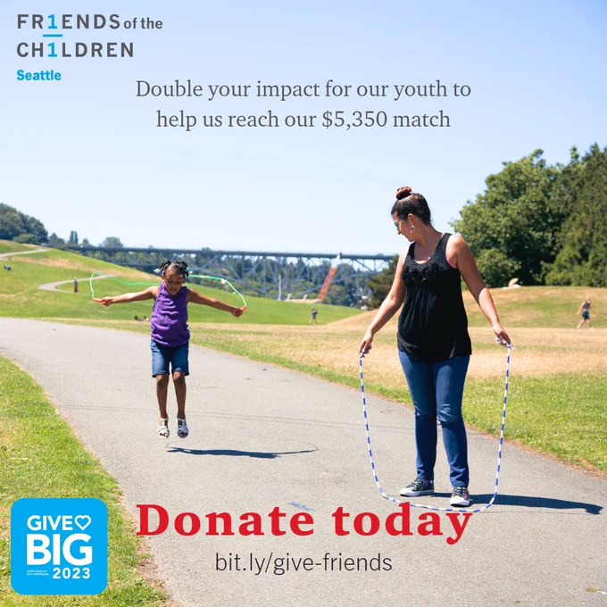 Elementary youth jump ropes with their mentor at a park. The park shows a grassy plain, concrete paths, with a green bridge in the background. The caption states: "Make an impact in our youths' lives", at the bottom it says "Donate Today" in red featuring a blue Give BIG 2023 logo.