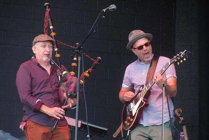 Bagpipe player and guitar player from the band Enter the Haggis play ing during Milwaukee Irish Fest 2022.
