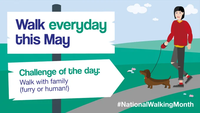 A National Walking Month graphic with the following text: 'Walk everyday this May - Challenge of the day: Walk with family (furry or human!)' featuring an illustration of a white woman with black hair and a brown dog walking along a path with green hills in the background.