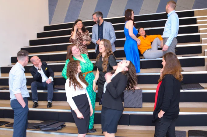 Whole team laughing together in the auditorium