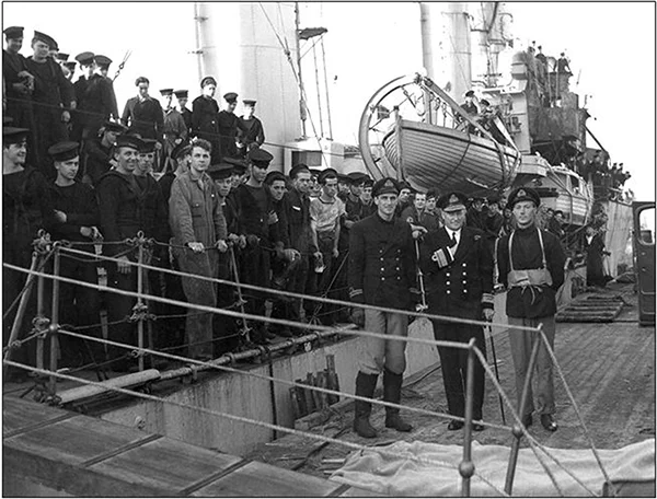 Black and white photo. Rear-Admiral L.W. Murray, Flag Officer Newfoundland, greets the crew of the destroyer Assiniboine at St. John’s.