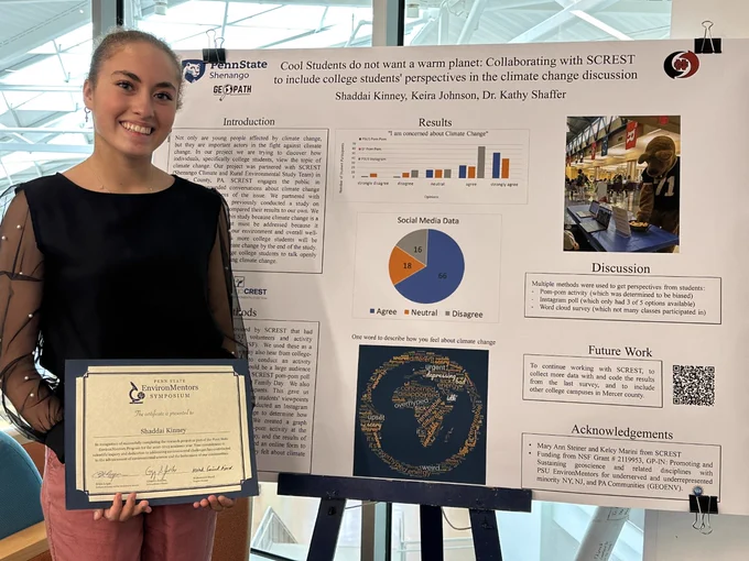 High School research mentee Shaddai Kinney poses with her research poster presentation