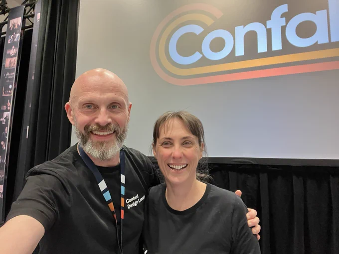 Mark and Sarah in front of the screen with ‘Confab’ on it.