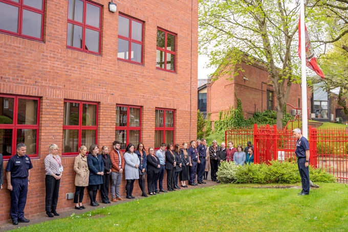 Staff outside our headquarters with the flag at half mast