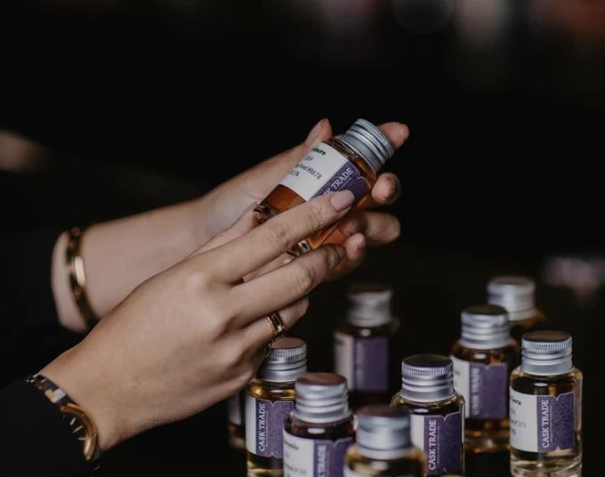 a female hand inspects cask whisky samples with the intention of investment 