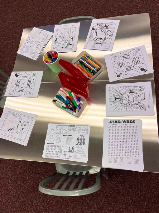 A table of Star Wars themed coloring pages and activity sheets, with containers of colored pencils and markers