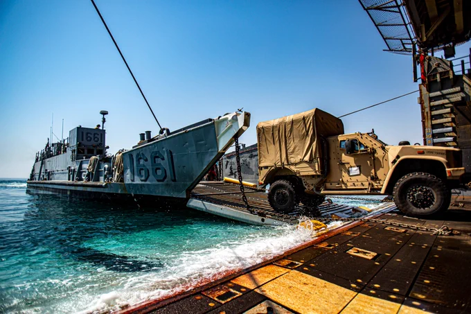Image: A joint light tactical vehicle attached to the 24th Marine Expeditionary Unit (MEU) is transferred from dock landing ship USS Carter Hall (LSD 50) to Landing Craft Utility 1661 during vehicle and equipment loading operations in the Arabian Gulf
