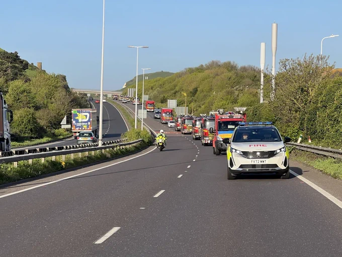 A convoy of fire and rescue vehicles driving on the road.