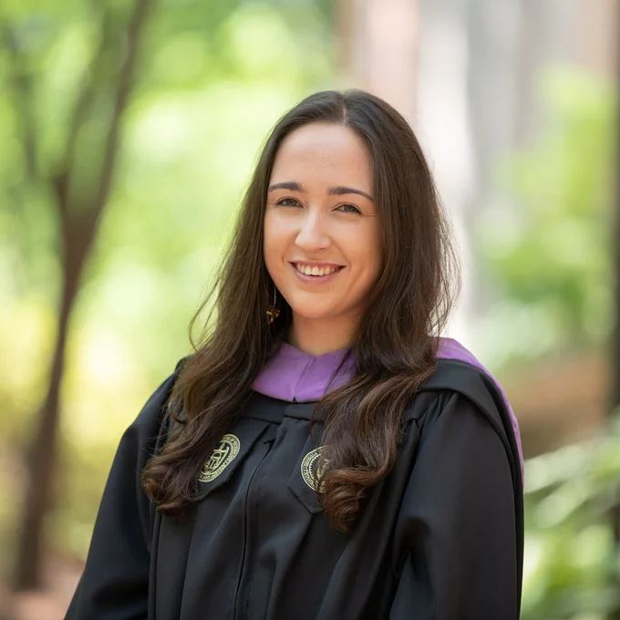 Outdoor portrait of Heidi Davari wearing commencement robes