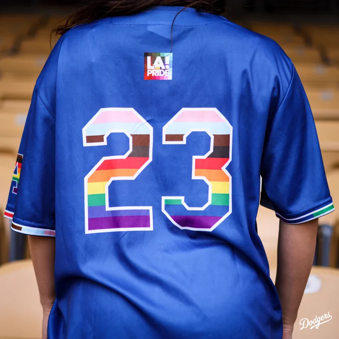 A photo of the back of the jersey for the LGBTQ  Pride Night jersey. There is an LA Pride logo at the top center of the jersey. Just below it is a big 23 with colors of the pride rainbow flag inside the number.