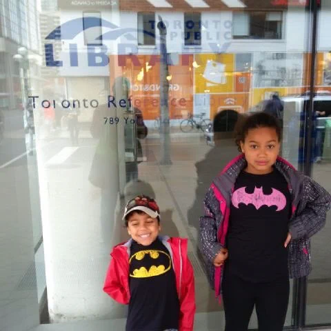 Jackson and Zoe standing up in front of the Reference Library windows