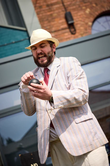 Man in fedora and blazer with pipe points furiously at black bowl