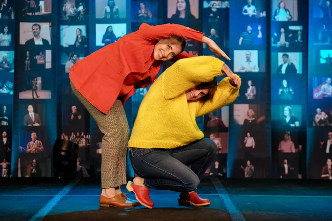 Attendees form the Confab logo in colorful sweaters on the main stage.
