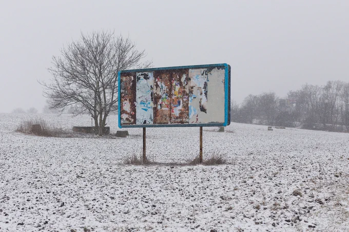 A colourful peeling billboard in a snowy field