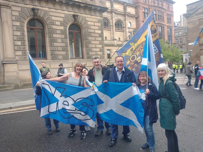 Chris Stephens MP with six Yes Pollok members, they are holding Yes flags and all smiling.