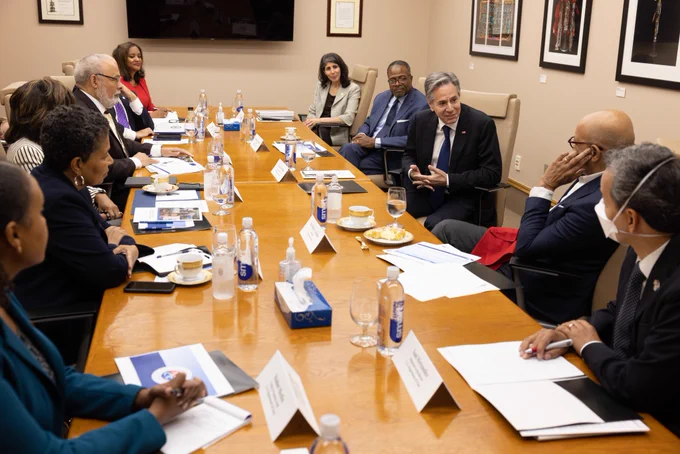 Secretary Blinken has a conversation with leaders of Atlanta’s four historically black colleges and universities. The group sits around a rectangular conference table in a meeting room.