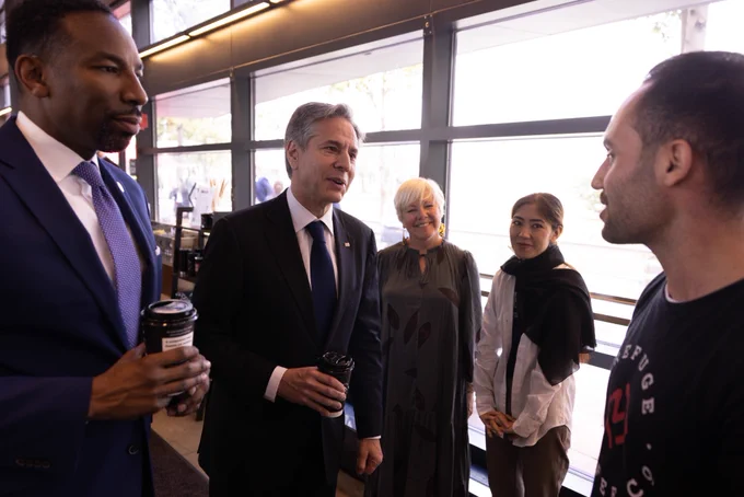 Secretary Blinken and Atlanta Mayor Andre Dickens converse with a staff member at Refuge Coffee.