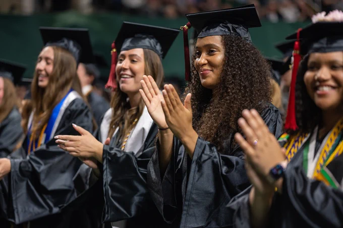 Students clap and smile during Spring 2023 Commencement.