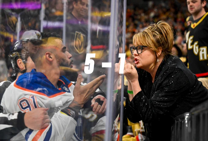 Evander Kane blowing a kiss to a Golden Knights fan holding up a finger with 5-1 over top. 