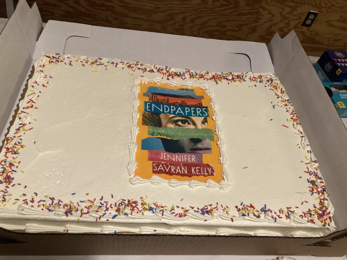 A large white sheet cake with a photo-realistic picture of the cover of ENDPAPERS in the center.