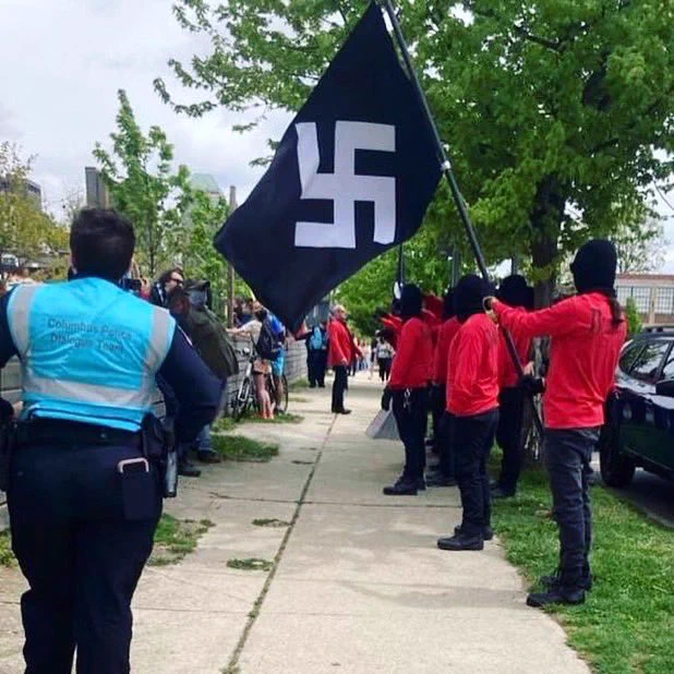 A photo documenting neo-nazis holding a flag with a swastika on April 29, 2023 in Columbus, Ohio. (Photo Credit: Andy Downing, cropped and unverified creator attribution)