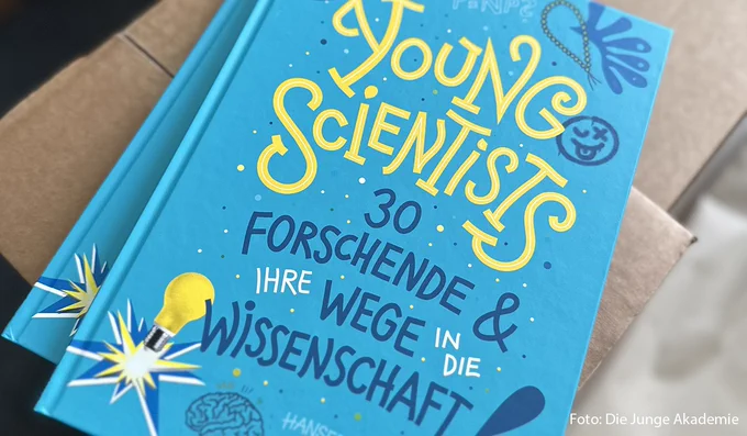 Zwei Exemplare des Kinderbuchs "Young Scientists" liegen auf einem Karton.