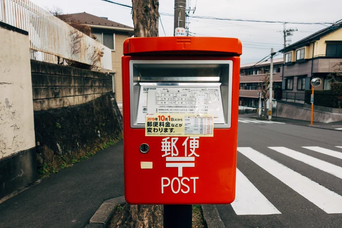 Square red Japanese post box on a pole in the street