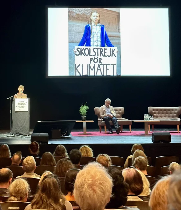 Hanna Belz am Rednerpult und Folie mit  Gretaa Thunberg