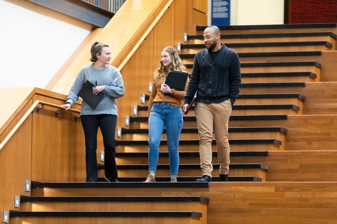 Photo of employees walking down steps, talking