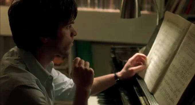 A man looks at sheet music in a still from The Beat That My Heart Skipped