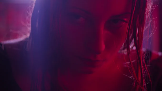 A woman bathed in red and blue light, in a still from Heaven Knows What.