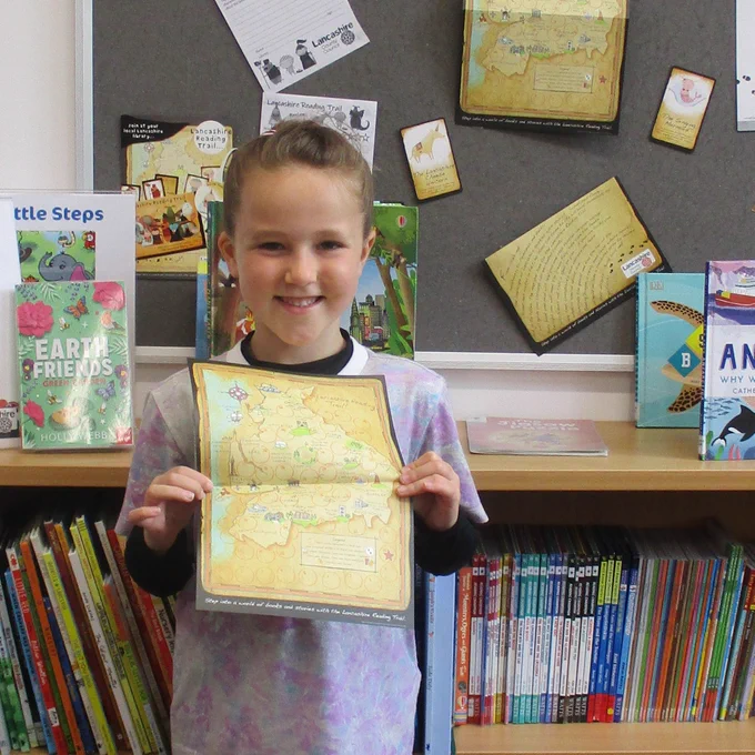 child holding lancashire reading trail map
