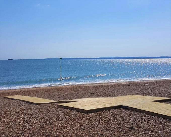 A wooden ramp going down Southsea Beach, allowing those on wheelchairs or with other mobility issues to go to the beach without having to navigate the pebbles.