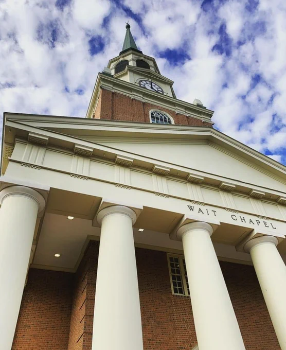 Wait Chapel at Wake Forest University on a sunny day with blue sky and clouds over the clock tower