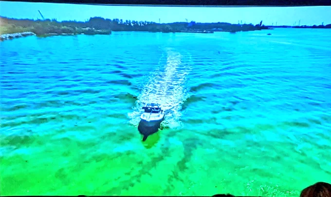 A boat driving through green algae 